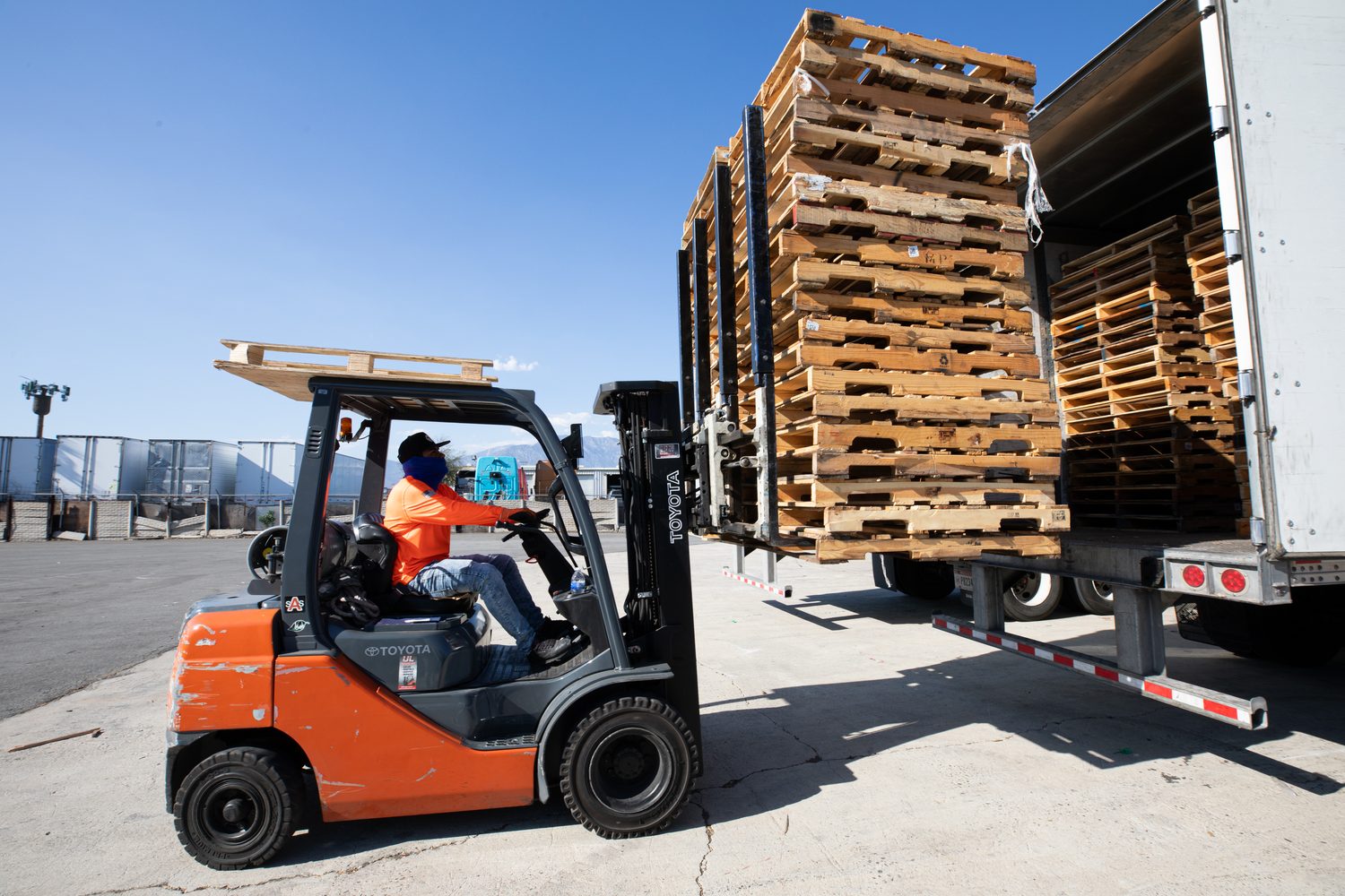 Forklift loading pallets onto a delivery truck